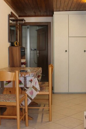 Ein Essbereich mit Holztisch und -stühlen, einem Schrank und einem Kleiderschrank.
