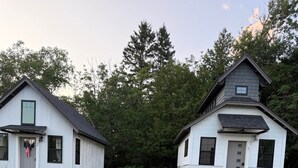 A gravel driveway leading to two white buildings with a deer and fawn nearby. - The Summit Suite | Walk to Rangeley Lake • ATV & Sled Access (Rangeley)