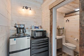 A compact kitchenette with a refrigerator, microwave, coffee maker, and a small sink. - The Summit Suite | Walk to Rangeley Lake • ATV & Sled Access (Rangeley)