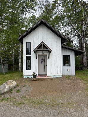 A small, single-story building with a gabled roof and a front door.