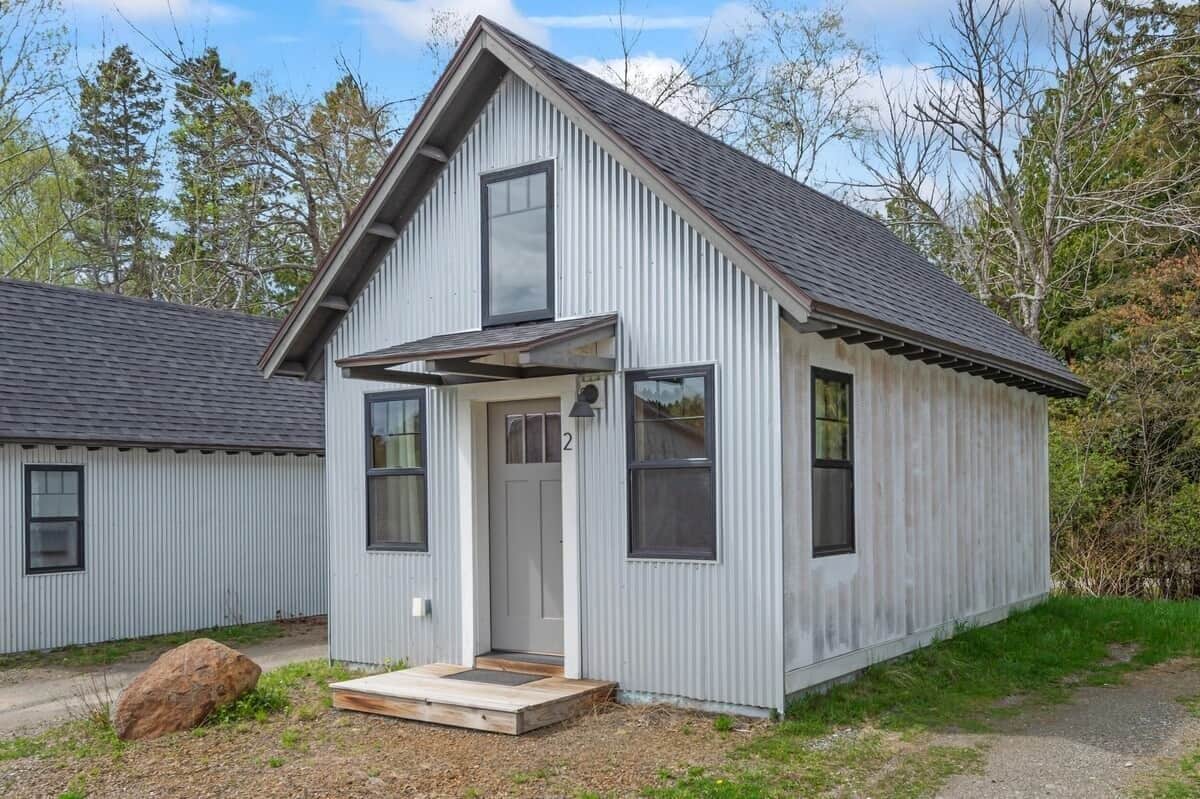 A small, single-story building with a gabled roof, a front porch, and a visible door number.