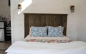 A bed with a wooden headboard, two patterned pillows, and a floral bedspread. - The Ridgeline | Near Saddleback • Walk to Rangeley Lake (Rangeley)
