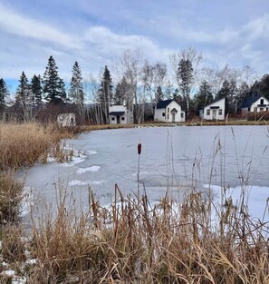 A frozen lake with houses in the background.