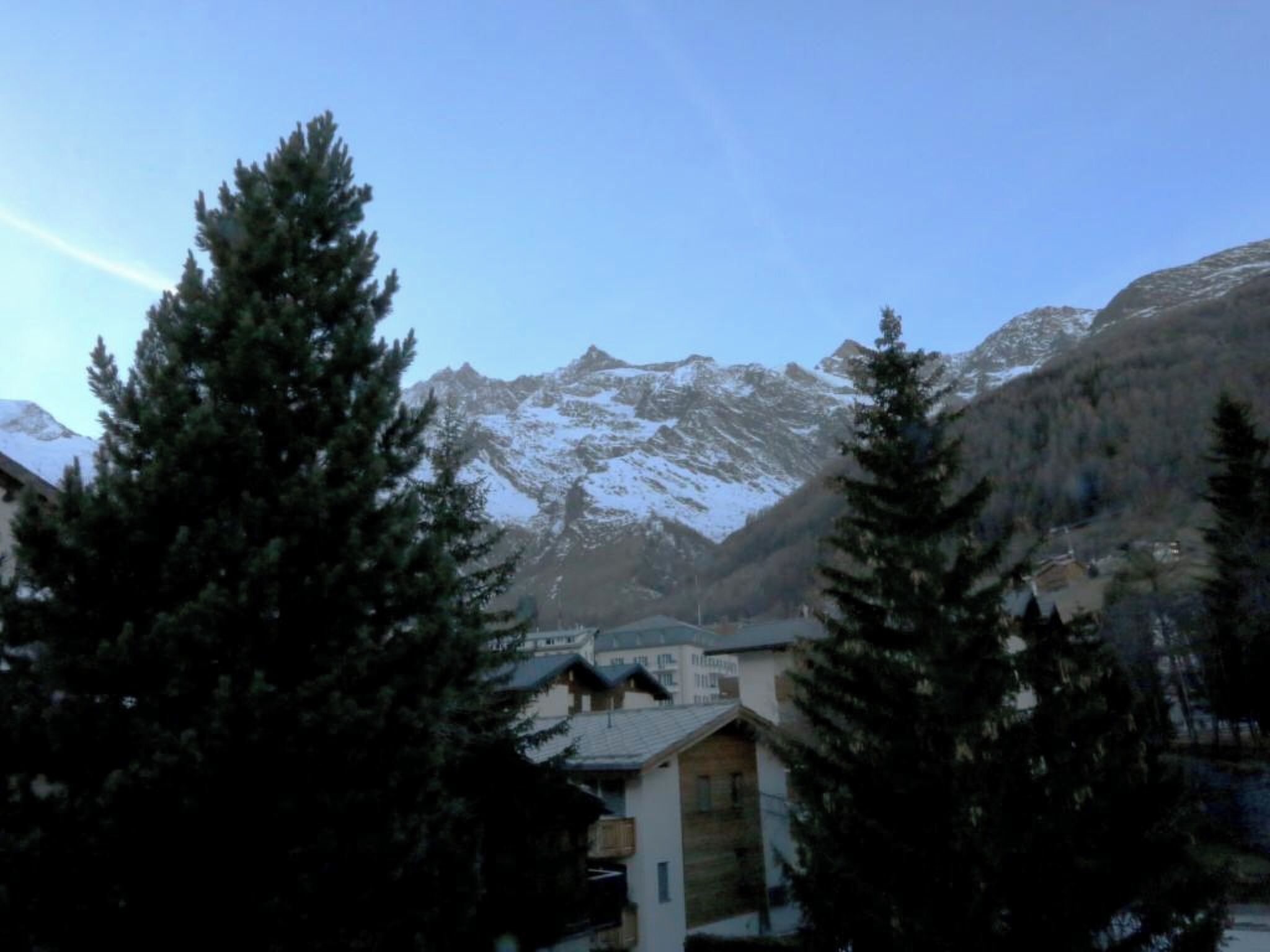 A mountain landscape with snow-capped peaks and a clear sky.