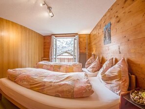 A wooden room with a bed, a window, and a view of a snowy landscape. - Anemone Appartement/Fewo 4-Bettwohnung Nr. 2 by Interhome (Saas-Fee)
