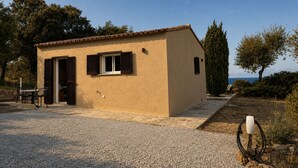 A small, single-story building with a tiled roof, a gravel driveway, and a single window with shutters. - Casa di Luce - Hot tub & beach within walking distance, ocean view (Corbara)