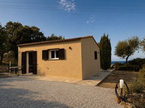 A small, single-story building with a tiled roof, a gravel driveway, and a single window with shutters. - Casa di Luce - Hot tub & beach within walking distance, ocean view (Corbara)