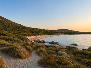 A coastal path leading to a beach with a clear view of the sea and a hilly landscape in the background. - Casa di Luce - Hot tub & beach within walking distance, ocean view (Corbara)