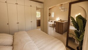 A bedroom with a large bed, a wardrobe, a mirror, and a kitchenette area. - Casa di Luce - Hot tub & beach within walking distance, ocean view (Corbara)