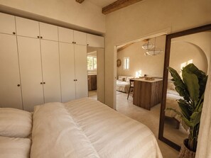 A bedroom with a large bed, a wardrobe, a mirror, and a kitchenette area. - Casa di Luce - Hot tub & beach within walking distance, ocean view (Corbara)
