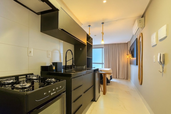 Una cocina moderna con estufa a gas, un lavamanos y un comedor con mesa y sillas.