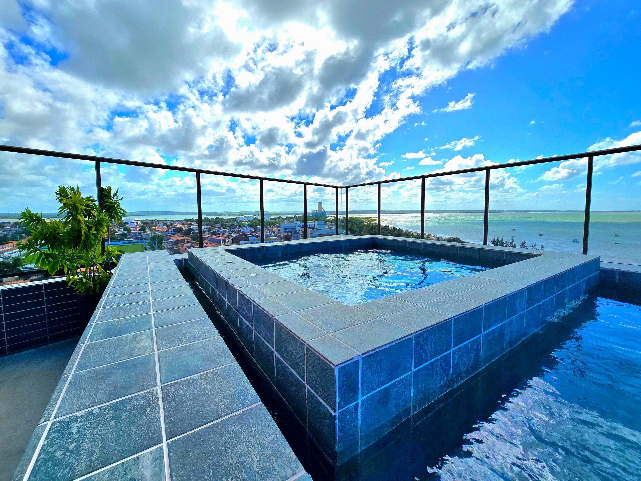 A rooftop infinity pool with a clear view of the city and ocean.