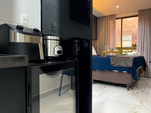 A modern kitchen with a built-in coffee maker and a refrigerator. - Dva Flats By Hosppedar (Cabedelo)