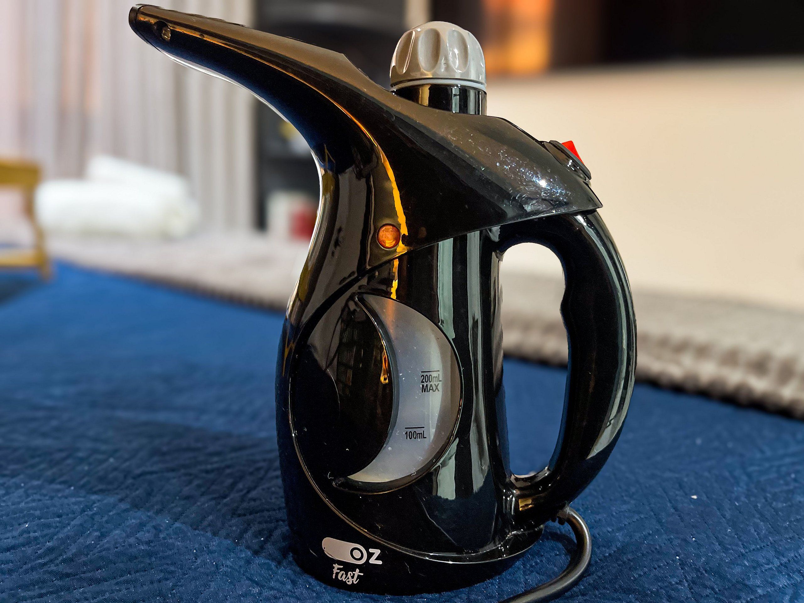 Una tetera negra con capacidad máxima de 200 ml y una marca de medición de 100 ml, además de un asa.