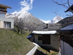 A residential area with a house, a small building, and a mountain in the background. - Fee-Rien Appartement/Fewo 4-Bettwohnung by Interhome (Saas-Fee)