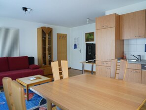 A compact living space with a dining table, chairs, a sofa, a kitchenette, and a television. - Fee-Rien Appartement/Fewo 4-Bettwohnung by Interhome (Saas-Fee)