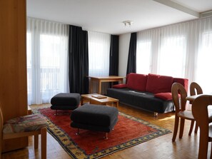 A modern living room with a sofa, ottoman, coffee table, and chairs. - Fee-Rien Appartement/Fewo, Bad, WC 6-Bettwohnung by Interhome (Saas-Fee)