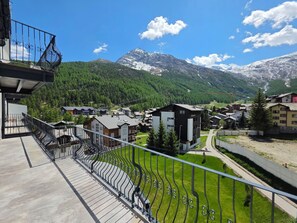 Ein Wohngebiet mit Häusern, einem Balkon und einem Berg im Hintergrund.