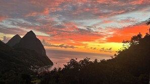 A coastal landscape with mountains, a body of water, and a sunset. - Wake up to views of the Pitons, Sea & Soufriere from this  hillside villa. (Soufriere)