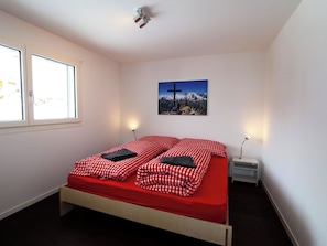 A bedroom with a bed, a window, a wall-mounted picture, and bedside lamps. - Perrine 1 Appartement/Fewo Appartement/Fewo by Interhome (Saas-Fee)