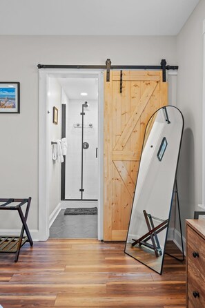Une pièce dotée d’une porte coulissante en bois, d’un miroir et d’un plancher en bois.
