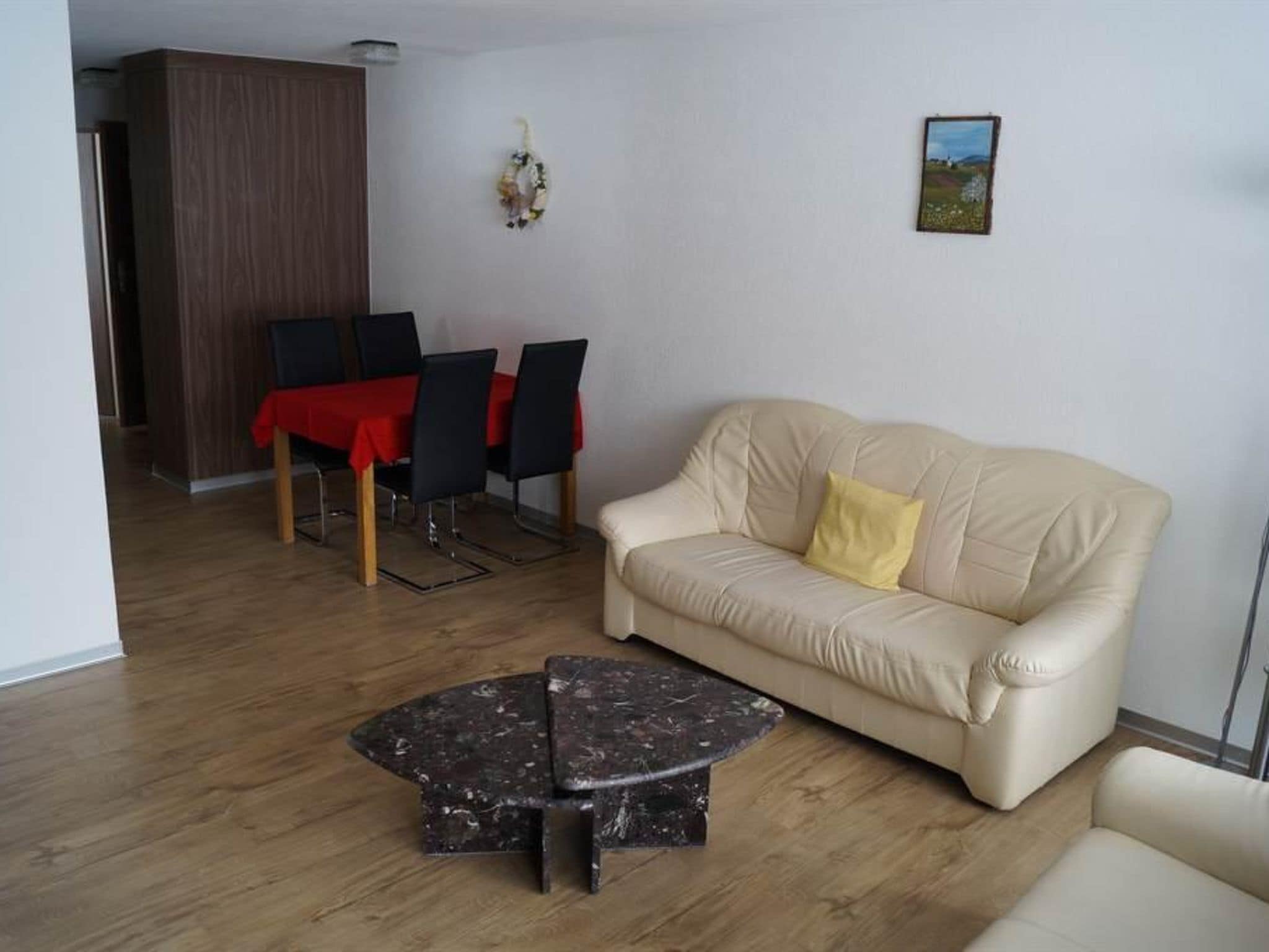 Ein Wohnzimmer mit einer Couch, einem Couchtisch und einem Essbereich mit Stühlen und einem Tisch.