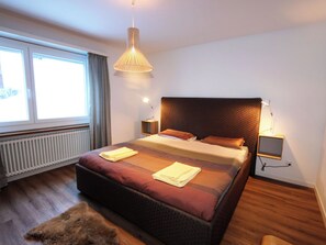 A modern bedroom with a large bed, bedside lamps, a window, and a radiator. - Apollo Appartement/Fewo 4-Bettwohnung Nr. 7 by Interhome (Saas-Fee)