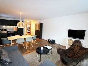 A modern living room with a grey sofa, a black coffee table, and a television. - Apollo Appartement/Fewo 4-Bettwohnung Nr. 7 by Interhome (Saas-Fee)