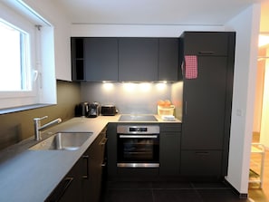 A modern kitchen with a built-in oven, a coffee machine, and a sink. - Apollo Appartement/Fewo 4-Bettwohnung Nr. 7 by Interhome (Saas-Fee)