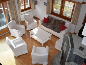 Ein Wohnzimmer mit einer Couch, zwei Sesseln und einem Couchtisch.