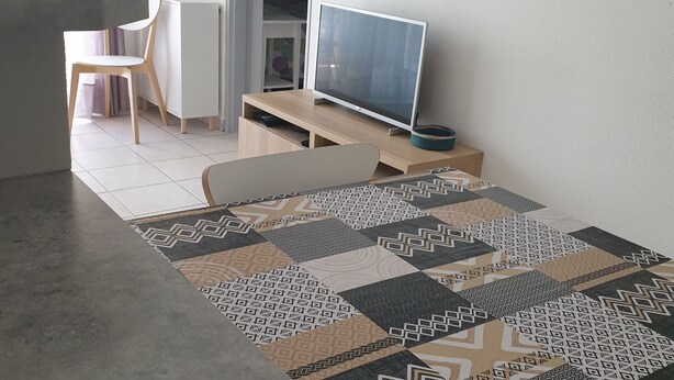 A modern living room with a sofa, a dining table, and a television. - Apartment near the beach (Menton)