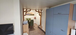A hallway with a wooden door, a table with chairs, and a painting on the wall. - Vacation Rental on the North Sea Coast: Holtgast-Fulkum (Holtgast)