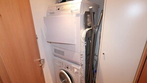 A compact laundry room with stacked appliances including a dryer, washer, and iron. - Aramis Appartement/Fewo 6-Bettwohnung Nr. 2 by Interhome (Saas-Fee)