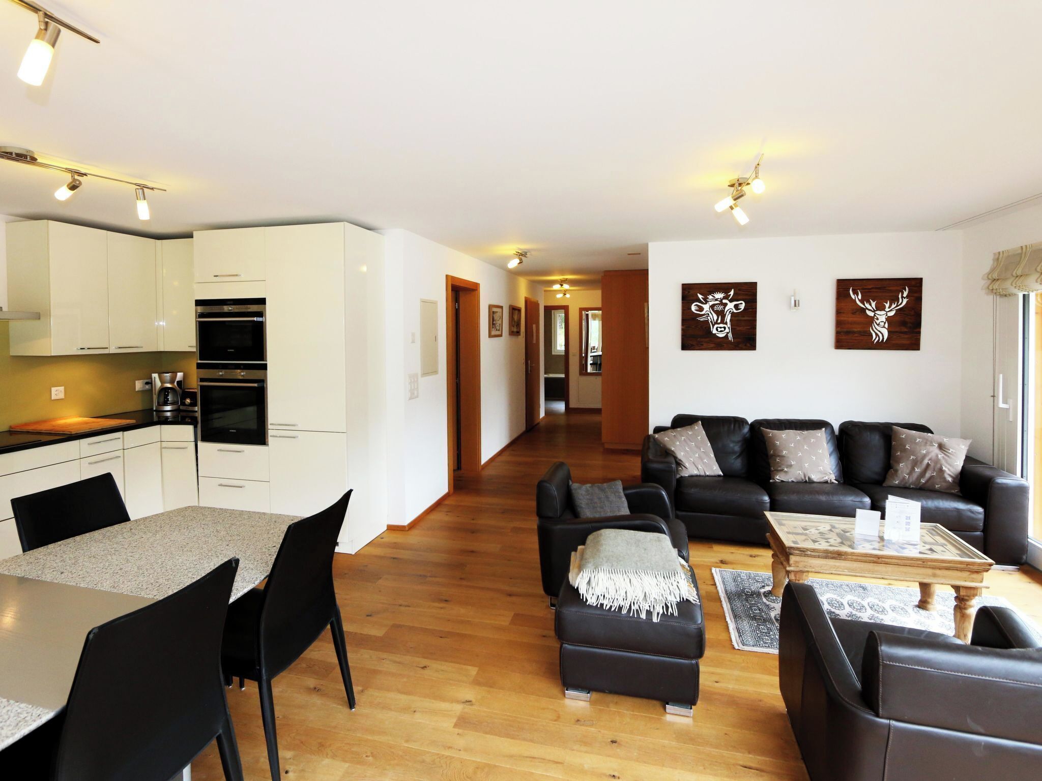 Eine moderne Wohnung mit Küche, Essbereich und Wohnzimmer.