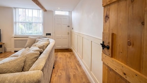 A room with a long wooden bench, a white door, and a window with blinds. - Stone-Walled 1-Bed with Fireplace · Sleeps 2 by St Edward`s Church, Castle Donington (Castle Donington)