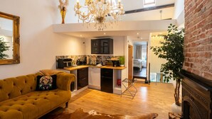 Ein modernes Interieur mit einer Couch, einer Küche und einem Kamin.