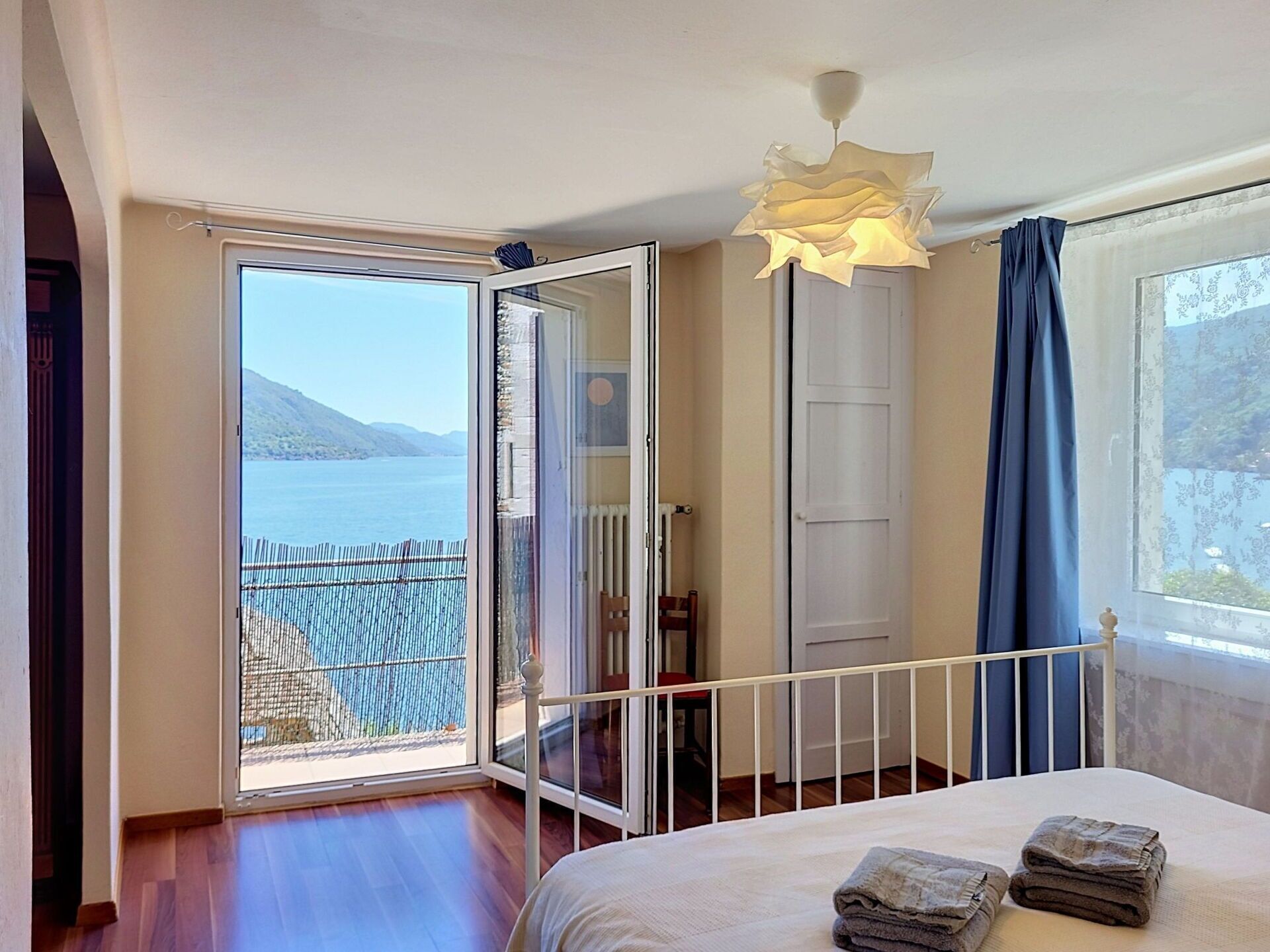 Une chambre avec un lit, une vue sur la mer et un balcon.
