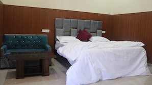 Un dormitorio con una cama, un sofá y una mesita.
