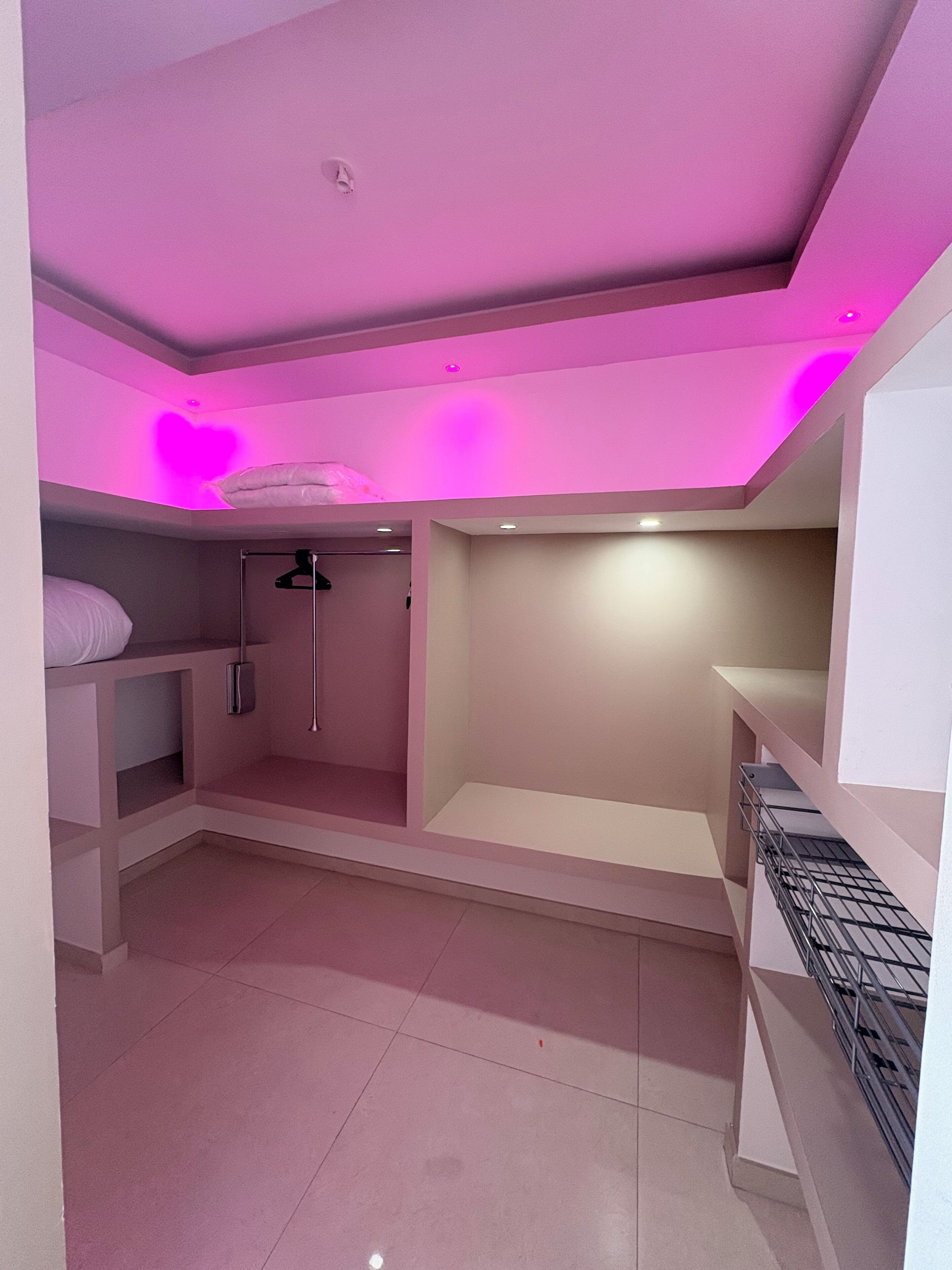 Habitació amb un llit superposat, dutxa i una prestatgeria amb una estructura metàl·lica.
