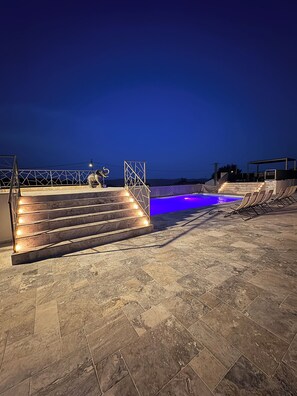 A pool area with a set of stairs leading to a platform, surrounded by a railing and a pool with blue lighting. - The prestigious Cévenol (Saint-Martin-de-Valgalgues)