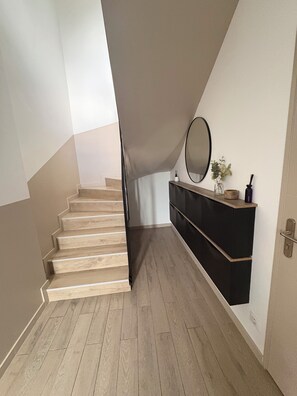 A staircase leading to a loft bedroom with a wooden floor, a black dresser, and a mirror on the wall. - The prestigious Cévenol (Saint-Martin-de-Valgalgues)