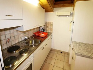 A compact kitchen with a double sink, a stove, and a microwave. - Sarazena Appartement/Fewo 2-Bettwohnung X by Interhome (Saas-Fee)