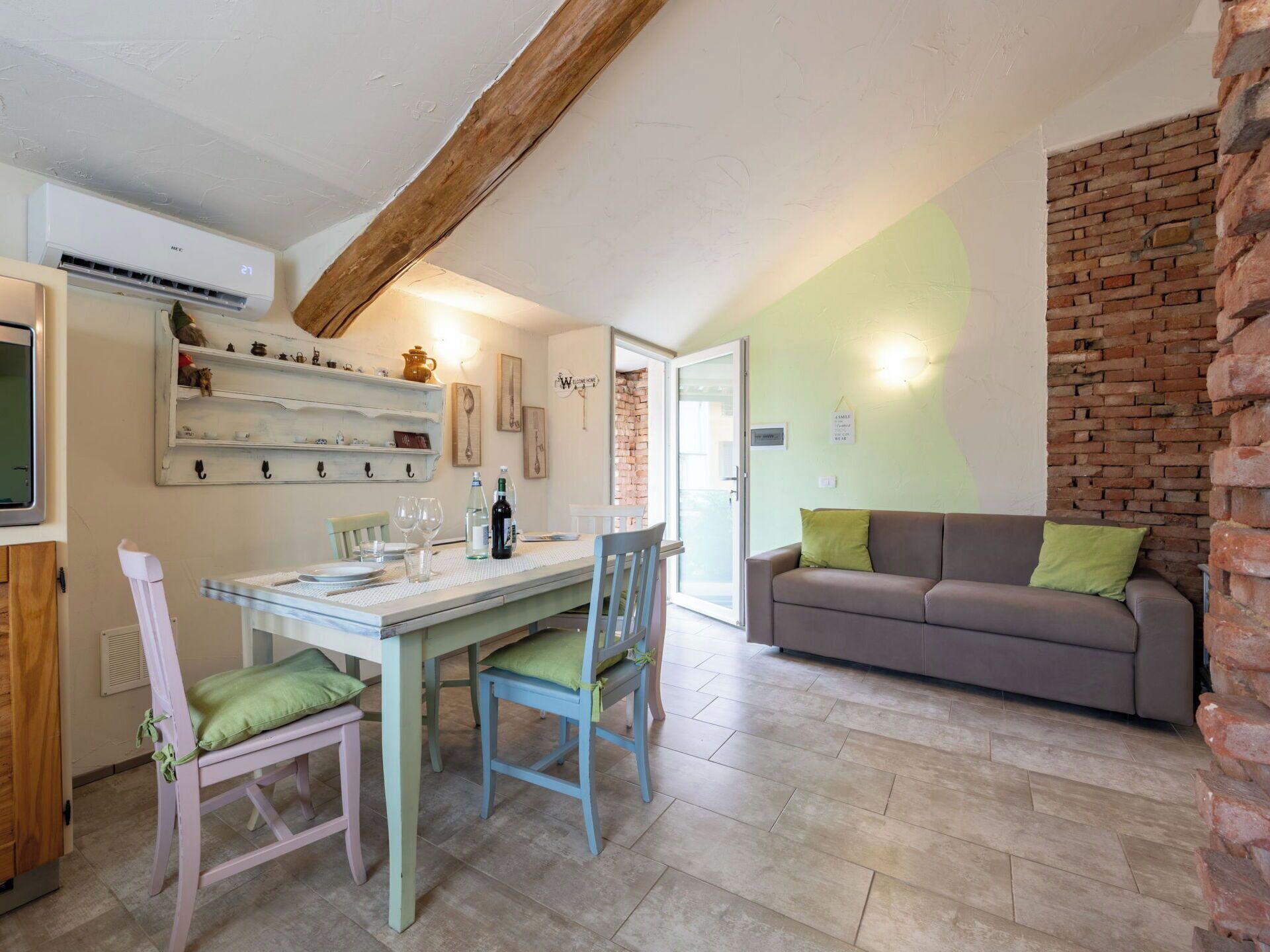 Un intérieur chaleureux avec un coin repas, un canapé et un mur en briques.