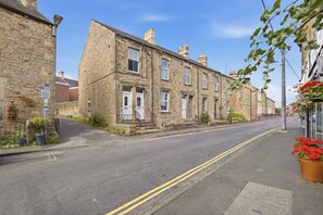A street with stone buildings, a clear sky, and a double yellow line on the road.