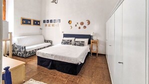 Un dormitorio con cama, sofá, armario y decoraciones en la pared, incluyendo estrellas y una luna creciente.