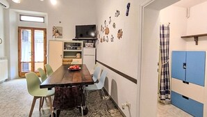 Un comedor con una mesa de madera, sillas y un televisor en la parte superior.