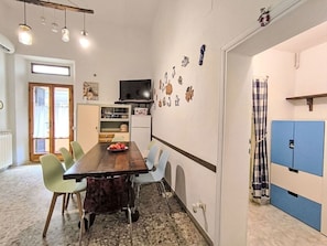 Ein Essbereich mit einem Holztisch, Stühlen und einem Fernseher darüber.