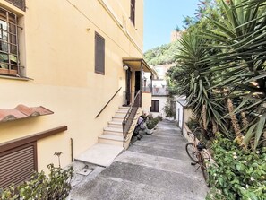 A narrow alleyway with a yellow building, a staircase, and a bicycle. - Nice apartment for 5 guests with A/C, WIFI and TV (Castiglione Della Pescaia)