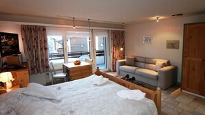 A bedroom with a bed, a desk, a sofa, and a window. - Sarazena Appartement/Fewo 2-Bettwohnung O by Interhome (Saas-Fee)