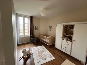 A room with a crib, a rocking horse, a wardrobe, and a window with shutters. - Large family home on the banks of the Loire River, perfect for cycling and visiting castles (Veuzain-sur-Loire)